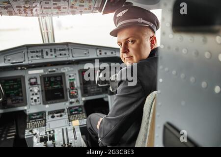 Male pilot in cockpit of passenger airplane jet Stock Photo