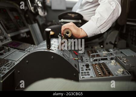 Pilot use steering to fly on passenger airplane Stock Photo