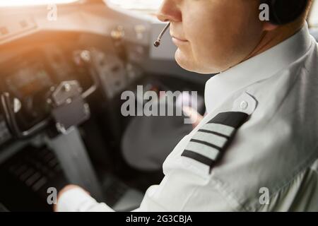 Male pilot in cockpit of passenger airplane jet Stock Photo