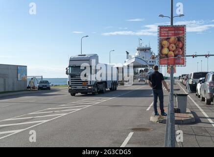 Car-ferry docked in port Virtsu, Estonia on Baltic Sea. Ro-ro ship in a sea harbor close-up. The trucks, buses, and cars leave the ship. Stock Photo