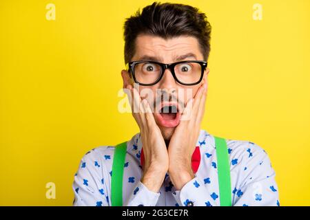 Close-up portrait of attractive worried guy wearing print shirt bad news reaction isolated over bright yellow color background Stock Photo