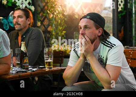 Munich, Germany. 15th June, 2021. Football: European Championship, France - Germany, preliminary round, Group F, 1st matchday: Guests of the Kilians Irish Pub watch the match on a monitor. Credit: Tobias Hase/dpa/Alamy Live News Stock Photo