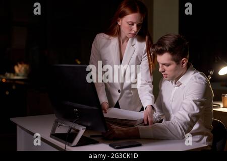 office worker man is tired of receiving instructions and tasks from female director, get a lot of papers and directions or instructions. finance, offi Stock Photo