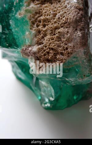 Textured turquoise glass rock detail on white background Stock Photo