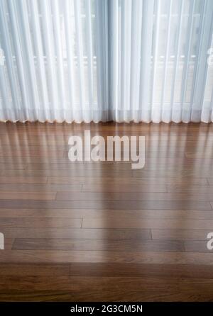 Vertical blinds cast shadows on a newly installed Brazilian Cherry hardwood floor Stock Photo