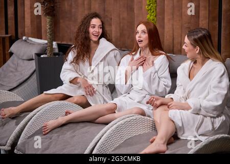 Three young caucasian women relaxing in spa and wellness center together, having conversation, enjoying vacation Stock Photo