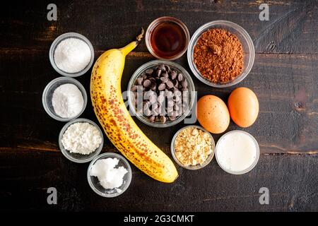 Peanut Butter Chocolate Chip Muffins Ingredients: Chocolate chips, peanut butter powder, and other ingredients on a dark wood background Stock Photo