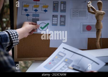 A close-up of an ux ui developer and an ui designer working on a mockup icon interface for a mobile app. Stock Photo