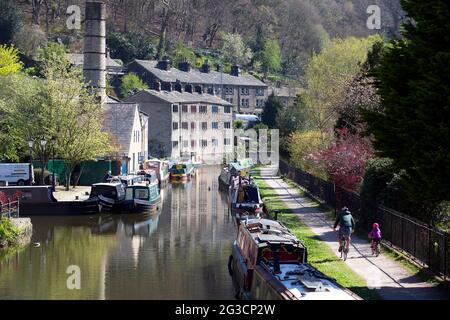 A father and child cycle down the canal in Hebden Bridge, west Yorkshire and and adhere to socail distancing as the coronavirus pandemic continues in Stock Photo