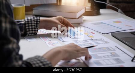 A close-up of an ux ui developer and an ui designer working on a mockup icon interface for a mobile app. Stock Photo