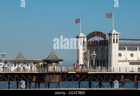 Entrance to Palace Pier on the Brighton, East Sussex UK sea front, showing illuminated neon sign.
