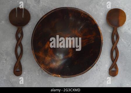 Empty round handcrafted brown wooden plate on stone concrete background, top view Stock Photo