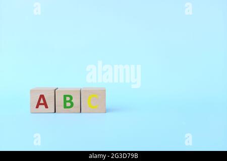 Colorful ABC letters on wooden blocks in blue background with copy space. Start of child or kid learning alphabet concept. Stock Photo