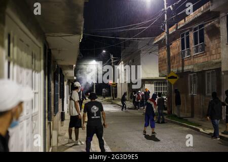 A tear gas canister pushes demonstrators into a neighborhood as demonstrators and Colombia's riot police (ESMAD) clash during the night of June 14, 2021, in Yumbo - Cali, Valle del Cauca - Colombia as Anti-government protests unveil into their 7th week against the government of president Ivan Duque, unrest and violence that had caused at least 70 dead.