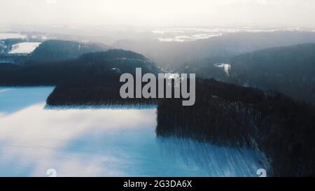 Drone view of Ojcow National Park or Ojcowski Park Narodowy in Krakow, Poland. Misty weather during the winter season. Area is covered with snow. Shot is taken during the bright sunny day.  Stock Photo