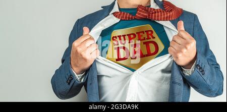 Man in a suit who opens his white shirt and tie to become a super hero, super dad. Father's day concept Stock Photo