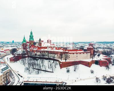 Panoramic view of the old Royal Wawel castle, cathedral in winter season. Wawel is a limestone hill in the center of Krakow upon the Vistula River. Clear white sky in the background.  Stock Photo