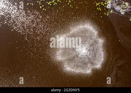 top down view of water fountain in the middle of lake making bubbles on water surface Stock Photo