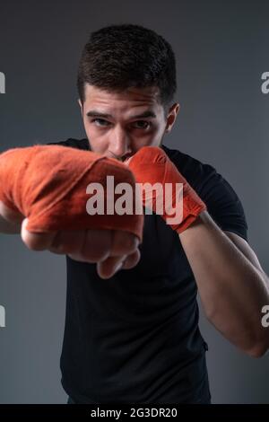 Sportsman throwing right straight punch with hand in wrist wraps Stock Photo