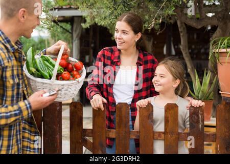 Man offers fresh vegetables to neighbors in country Stock Photo
