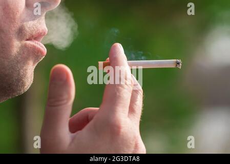 Cropped close up man smoking cigarette outdoors shot. Stock Photo