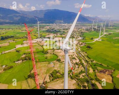 Wind turbine being repaired, assisted by crane and elevator. Wind power plant. green meadow with Wind turbines generating electricity Stock Photo