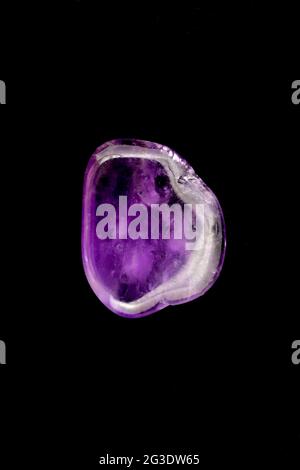 Amethyst jewel stone texture on black background. Macro closeup. Stock Photo