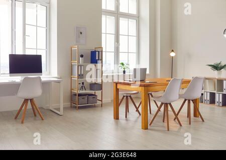 Side view of a bright office interior with modern tables, chairs and shelves. Stock Photo