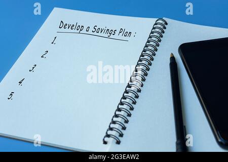 Text on notepad with pen and smartphone on blue background Stock Photo