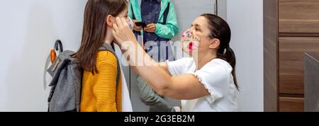 Mother putting the mask on her daughter Stock Photo