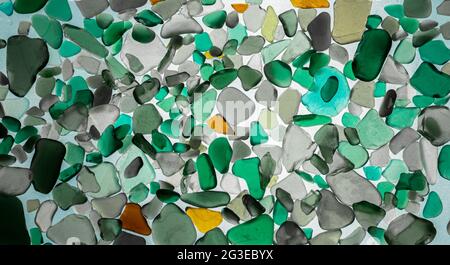 Summer background from sea glass top view. Broken glass from the ocean. Sea pattern. Oceanic mosaic. Natural colors of blue, green, white found on the Stock Photo