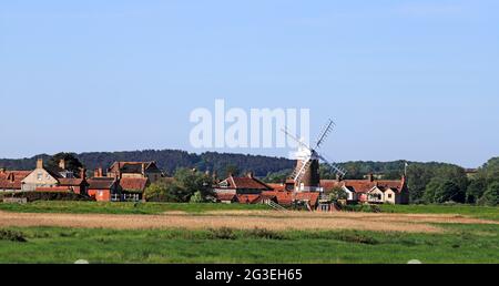 A view of Cley Next the Sea with landmark Windmill from the Norfolk Coast Path in North Norfolk at Cley, Norfolk, England, United Kingdom.