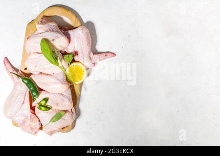 Raw uncooked chicken wings, ready for cooking, bbq, with herbs, vegetable, spices Stock Photo