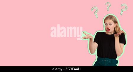 Beautiful young lady thinking with question marks overhead isolated over pink background. Stock Photo