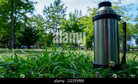 metallic camping thermos on beautiful autumnal background Stock