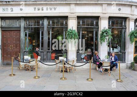 Friends sit outside The Ivy surrounded by empty tables in York town centre in north Yorkshire. Following the end of the Government’s August ‘Eat Out t Stock Photo