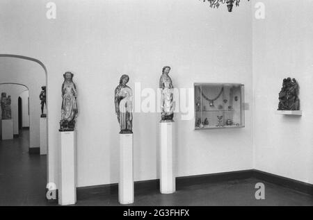 Room with various objects including images in showcases and on pedestals and a passage; Interiors West, setup in the early 1950s. . Stock Photo