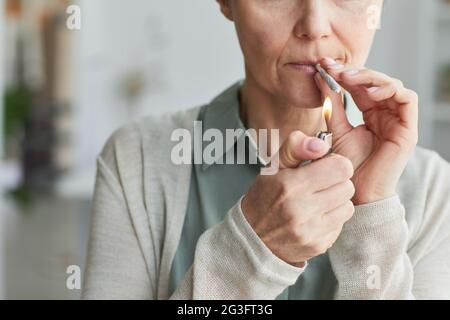 Close up of unrecognizable mature woman lighting cigarette while smoking for medicinal purposes, copy space Stock Photo