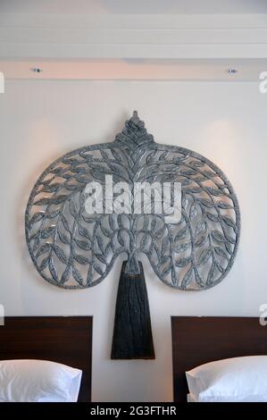 Traditional handmade Khmer mental tree used as bedhead decoration in a Siem Reap hotel room Stock Photo