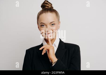 Smiling successful female lawyer in dark suit looking at camera with confident gesture Stock Photo