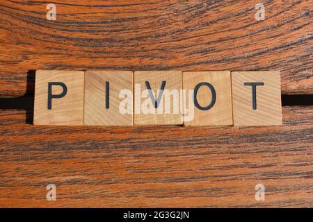 Pivot, business buzzword in wooden alphabet letters isolated on teak wood background Stock Photo