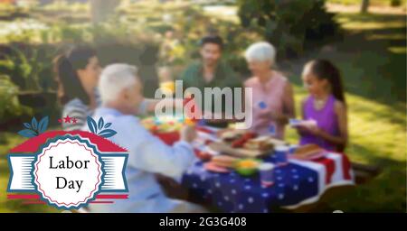 Composition of labor day text and logo over family having celebration picnic Stock Photo