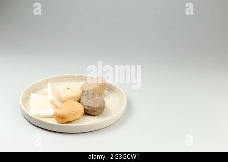 Handmade solid soap bars of different shape on white ceramic dish. Grey background with copy space for text. Zero waste, eco friendly product Stock Photo