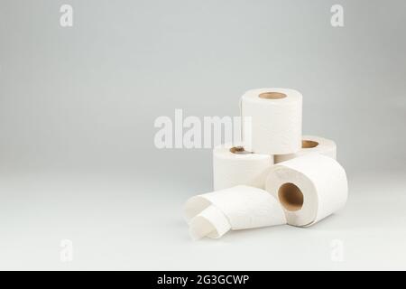 Rolls of Soft White Toilet Paper over Gray Background. Hygiene concept. Copy Space for text Stock Photo