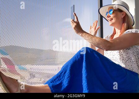 Female freelancer at airport. woman working with smartphone in airport until departure. Stock Photo