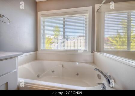 Closeup shot of a jacuzzi bathtub in a bathroom with big window and mirror Stock Photo