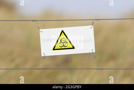 Border fence - Old plastic sign with a flag Stock Photo