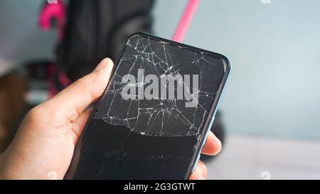 Phone with broken screen cracked, with abstract background close up Stock Photo