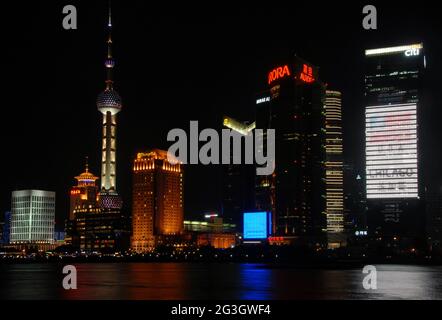 Pudong in Shanghai, China: View across the Huangpu River from the Bund looking towards the Pudong business district with illuminated towers. Stock Photo