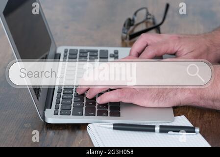 person using laptop computer on wooden table with search engine search box overlay, internet search and browsing concept Stock Photo